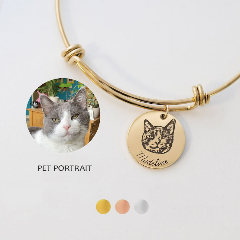 Engraved pet portrait bangle in gold tone with a cat portrait charm and the available metal colors.