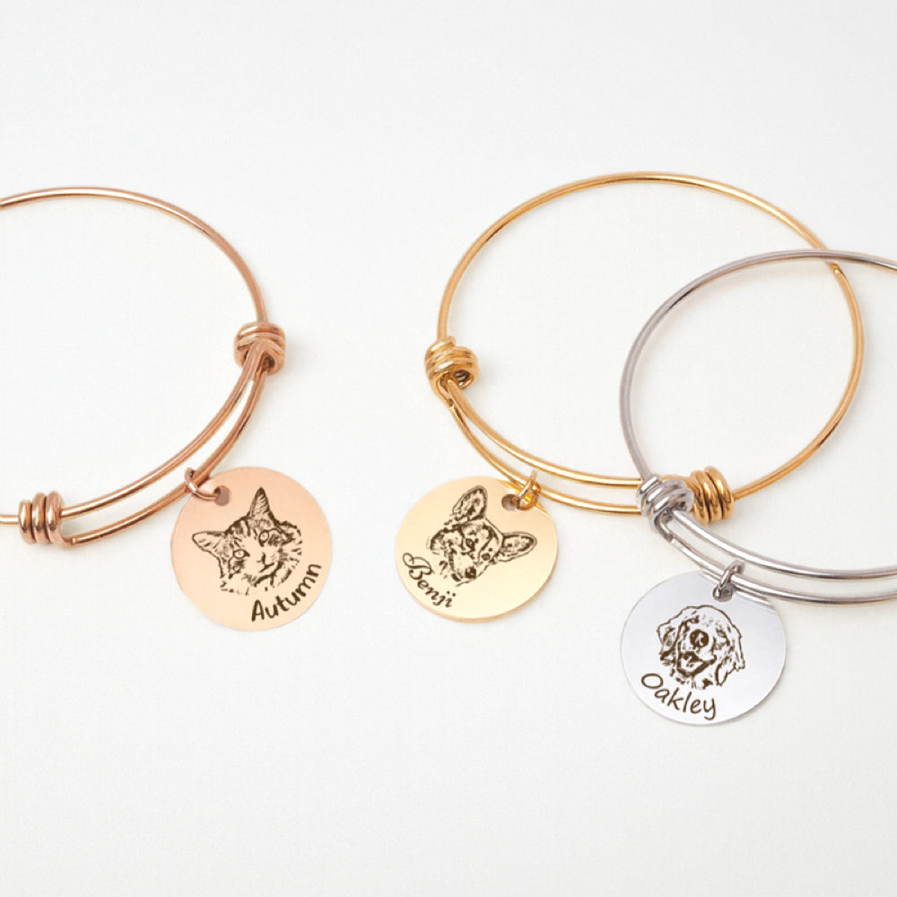 Engraved pet portrait bangle collection in rose gold, gold, and silver tones with pet charms.