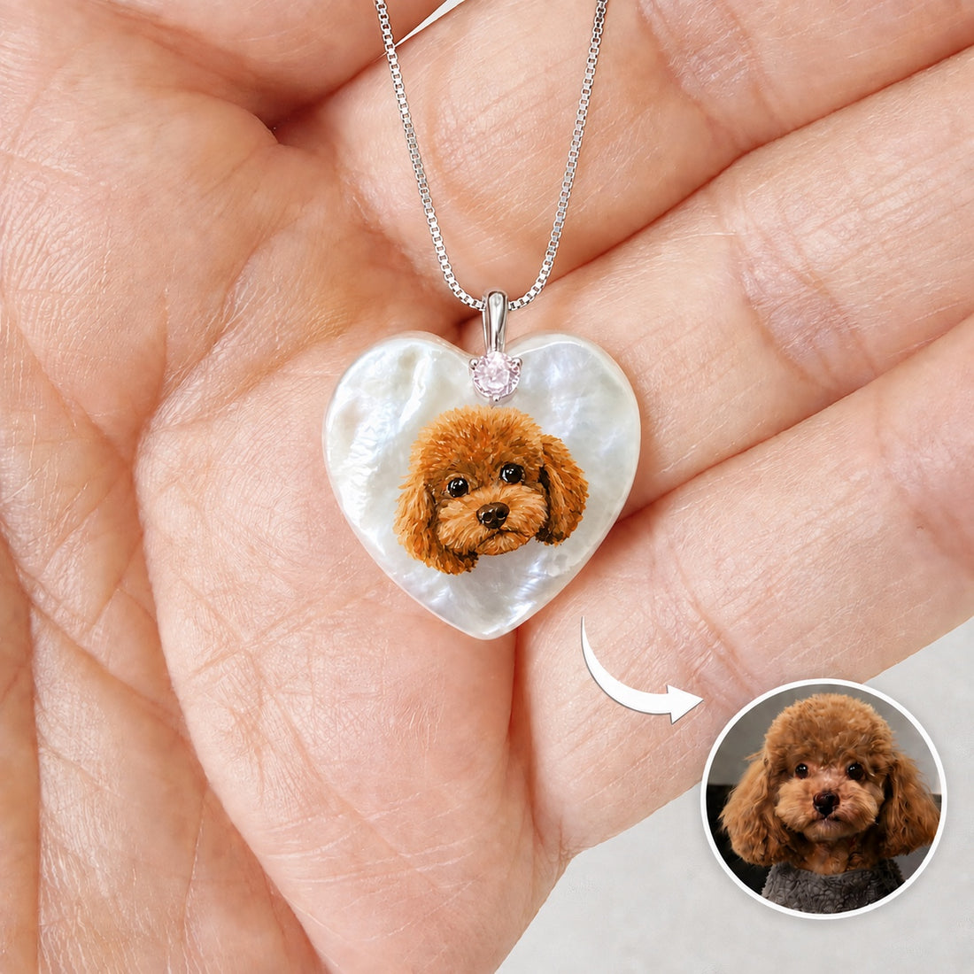 Hand-painted pet portrait pendant with a curly brown dog painted on a heart-shaped mother-of-pearl piece.